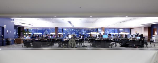 A view of the student learning commons with computers and tables filled with students