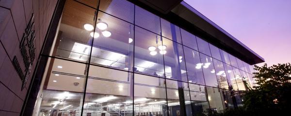 A view of the Health Sciences Library at night from outside the building