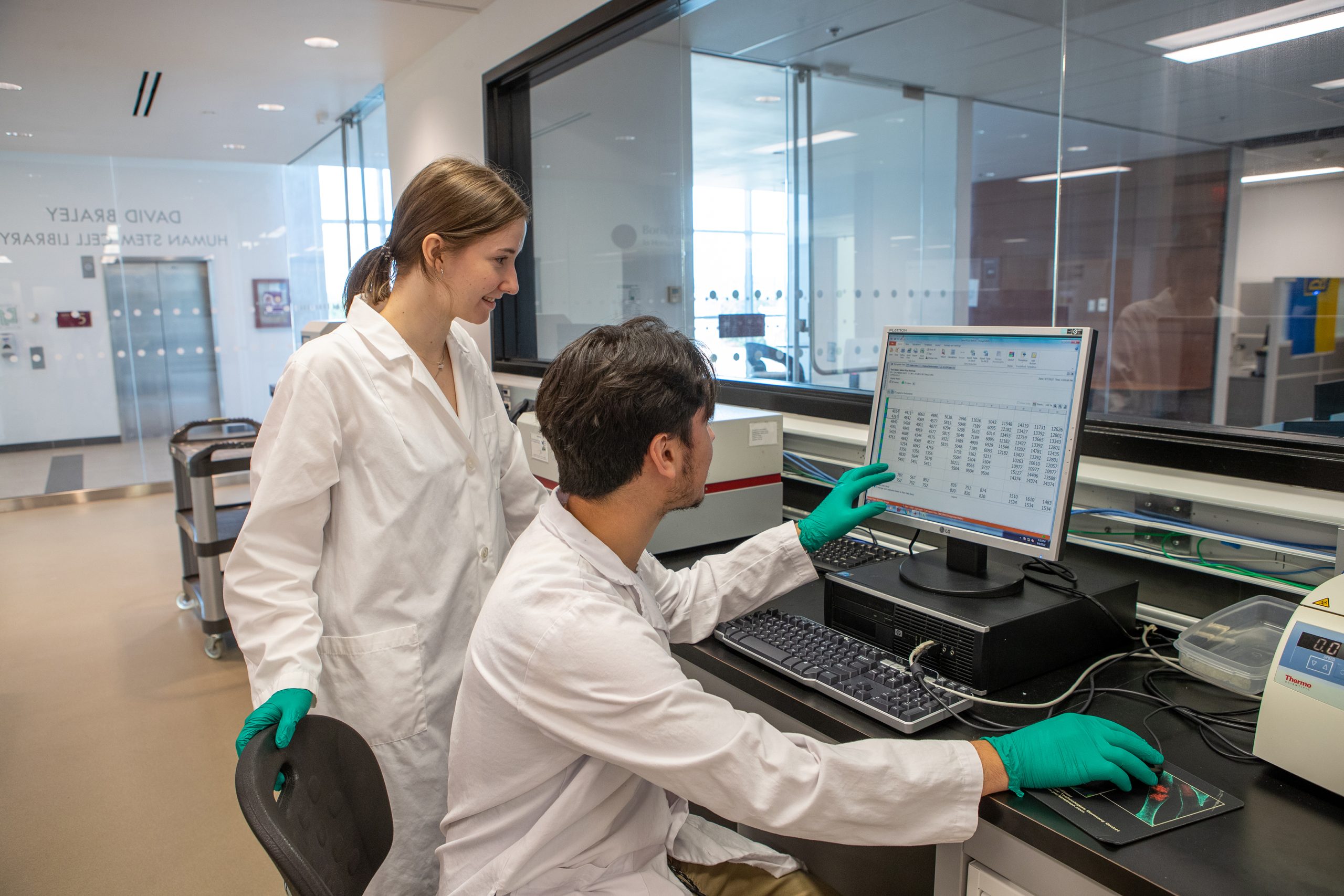 Two students conduct research in a lab affiliated with McMaster University's Centre for Discovery in Cancer Research.